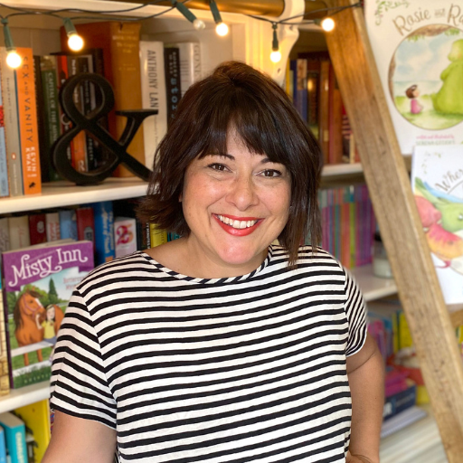 Author Serena Geddes in front of her bookshelf