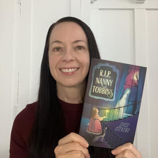 A smiling woman is holding a book