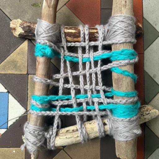 Sticks with blue and grey string forming a net